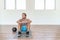 Fit man training exercise at home gym workout with weight medicine ball taking a break sitting on floor tired sweating