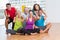 Fit men and women gesturing thumbs up in fitness studio