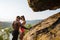 fit mixed race couple with perfect bodies in sportswear posing on the rocky mountains landscape