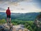 Fit mountain climber or hiker on a rocky summit looking down