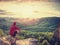 Fit mountain climber or hiker on a rocky summit looking down