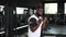 Fit and muscular african man lifting heavy barbell weight at the gym.