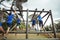 Fit people climbing monkey bars in bootcamp