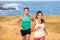 Fit run people couple jogging for fitness running on beach landscape nature outdoors. Woman and man sports athletes