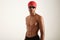 Fit serious African American swimmer in red cap and black goggles looking at the camera