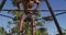 Fit, shirtless african american man exercising outside, doing hanging pull ups on a climbing frame