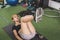 A fit and slender asian woman does knee pull ins while lying on a black mat at the gym