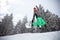 Fit snowboarder jumping with snowboard on ski terrain