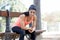 Fit sport woman looking at mobile phone internet app tracking performance after running workout sitting on park bench happy