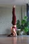 Fit sporty girl doing advanced yoga. Supported headstand, salamba sirsasana