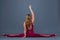 Fit sporty girl is stretching. Young beautiful gymnast woman in a jumpsuit doing cross split, twine. Sport is a flexible, healthy