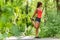 Fit stretch woman stretching quad leg muscle standing getting ready to run jogging outside in summer nature forest park
