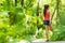 Fit stretch woman stretching quad leg muscle standing getting ready to run jogging outside in summer nature forest park green