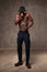 Fit strong physique African American young man wearing black hat and trousers posing dancing