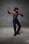 Fit strong physique African American young man wearing black hat and trousers posing dancing