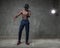 Fit strong physique African American young man wearing black hat and trousers posing dancing