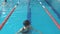 Fit swimmer girl jumping and cheering in swimming pool
