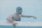 Fit swimmer male training swim in open winter swimming pool with fog. Geothermal outdoor spa concept,