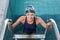 Fit swimmer smiling at camera getting out of the swimming pool