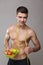 Fit vegan man with measuring tape and healthy food