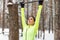Fit woman athlete performing pull ups in a bar. Winter street outdoor training workout.