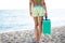 Fit woman carrying cooler box,portable fridge on the beach.Fit slim healthy woman in shorts for going to the beach with cooler