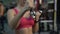 Fit woman doing dumbbell exercises, training in gym for strength and health