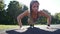 Fit woman doing full plank core exercise fitness training working out outdoors. Push up