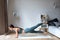 Fit woman doing yoga plank, training in living room