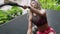 Fit woman engages in crossfit battle rope exercise, outdoor gym environment. Powerful biethnic female trains arms