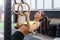 Fit woman going pull-ups with gymnastic rings in gym