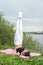 Fit woman making yoga in shoulderstand pose exercising in nature