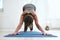 Fit woman in a meditative yoga pose at gym