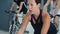 Fit woman spinning indoor bike at cycling class. Portrait sportive woman on bicycle training in gym club. Fitness people
