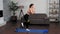 Fit woman in sportswear does sports training workout on fitness yoga mat at home