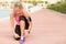 Fit woman tying sports shoe before morning exercise