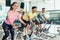 Fit women burning calories during indoor cycling class