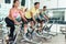 Fit women burning calories during indoor cycling class in a fitness club