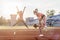 Fit women at the stadium playing leap frog.