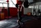 Fit young  athlete lifting the barbell in gym. Gym training. Full body length portrait.