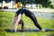 Fit young beautiful woman wearing black sporty leggings working out outdoors in park on summer day, doing Bridge Pose