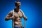 Fit young man with beautiful torso and a rope on blue background