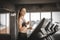 Fit young woman caucasian running on machine treadmill workout in gym. Glad smiling girl is enjoy with her training process.