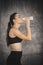 Fit young woman drinking milk from the bottle after exercise in gym. Beautiful woman at gym taking a break