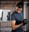 Fitness, arm and dumbbell with a sports man training in a gym for strong or healthy muscles. Bicep, exercise and