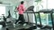 Fitness Asian woman in pink overcoat warm up fast walking and running on track treadmill machine