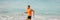 Fitness athlete man running fast sprinting on beach ocean water background banner. Profile of male runner explosive run