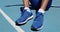 Fitness athlete runner getting ready to run tying shoe laces on stadium running track