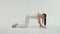Fitness athlete woman is dressed in white sportswear performs an exercise bridge lifting his one leg up