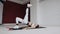Fitness athlete woman is dressed in white sportswear performs an exercise bridge lifting his one leg up, on the mat at